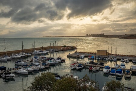 Cabo Roig marina with boats and Orihuela Costa coastline at dusk