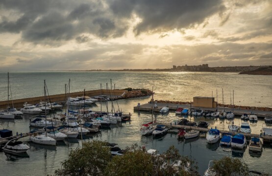 Cabo Roig marina with boats and Orihuela Costa coastline at dusk