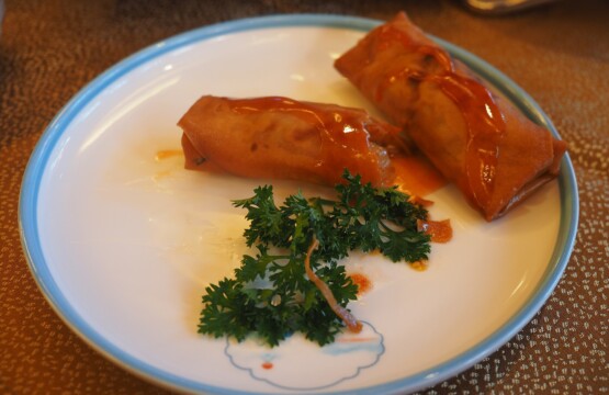 Crispy Chinese spring rolls with sweet and sour sauce on a restaurant plate