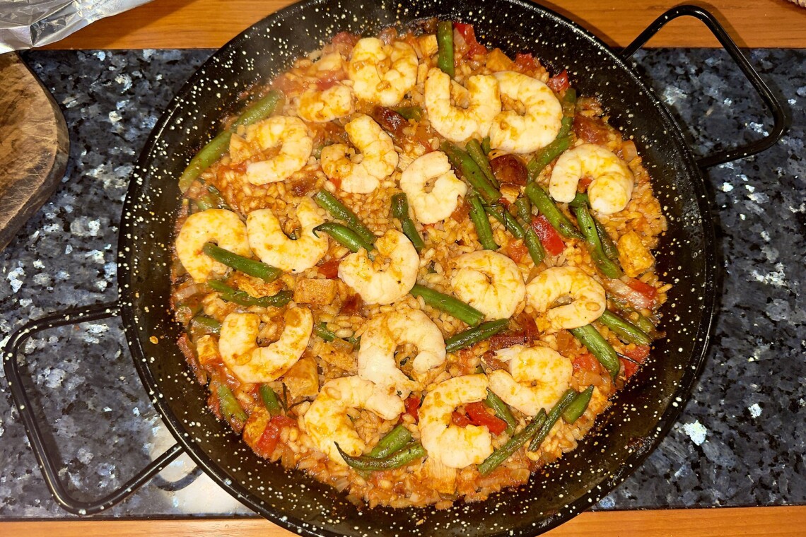Traditional Spanish mixed paella pan with prawns and green beans