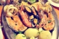 Spanish mixed seafood grill platter with prawns, mussels, squid rings, salmon and potatoes