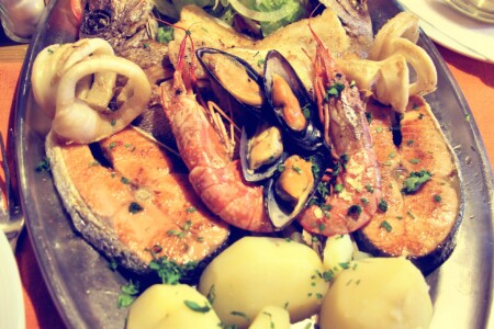 Spanish mixed seafood grill platter with prawns, mussels, squid rings, salmon and potatoes