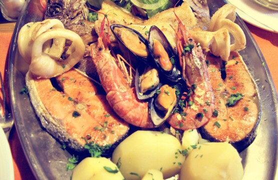 Spanish mixed seafood grill platter with prawns, mussels, squid rings, salmon and potatoes