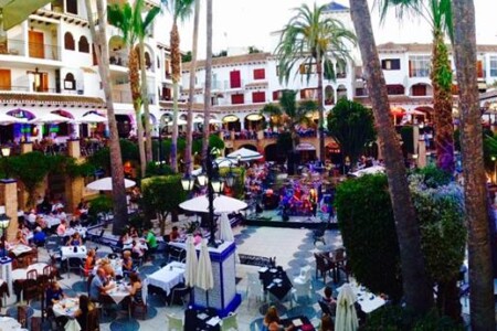 Villamartin Plaza dining square full of restaurant terraces on a summer evening
