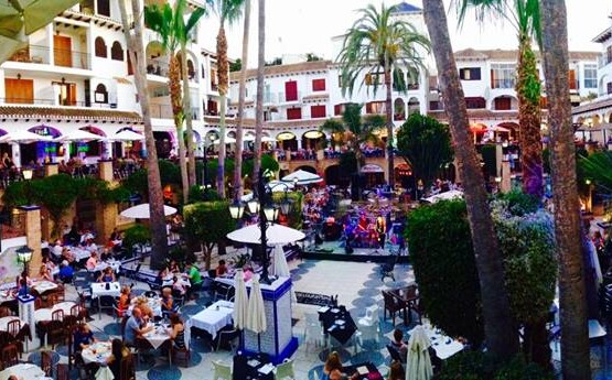 Villamartin Plaza dining square full of restaurant terraces on a summer evening