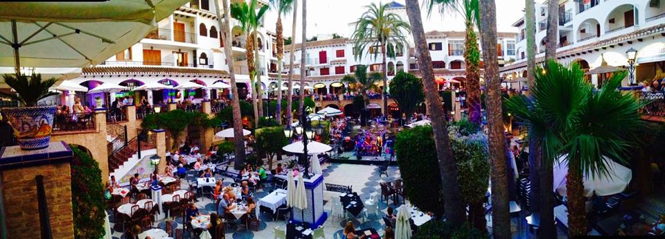 Villamartin Plaza dining square full of restaurant terraces on a summer evening